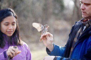 2 students hold small birds
